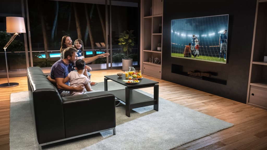 A family watches an exciting soccer game on TV together.