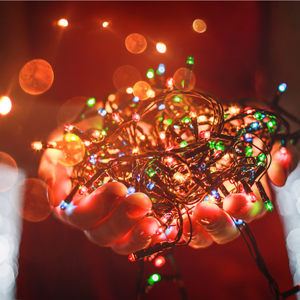 A person holds a handful of Christmas lights as they prepare to begin decorating.