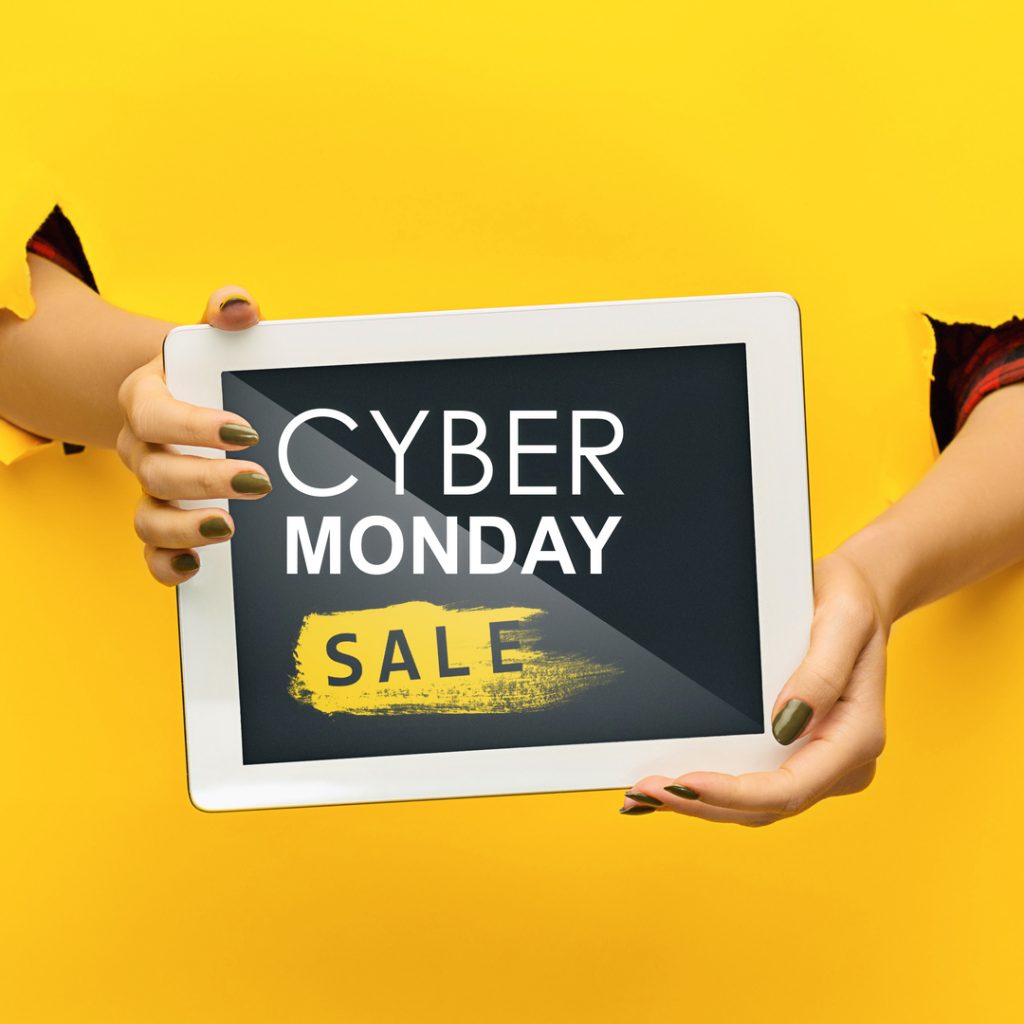 Hands holding a tablet announce a Cyber Monday sale.