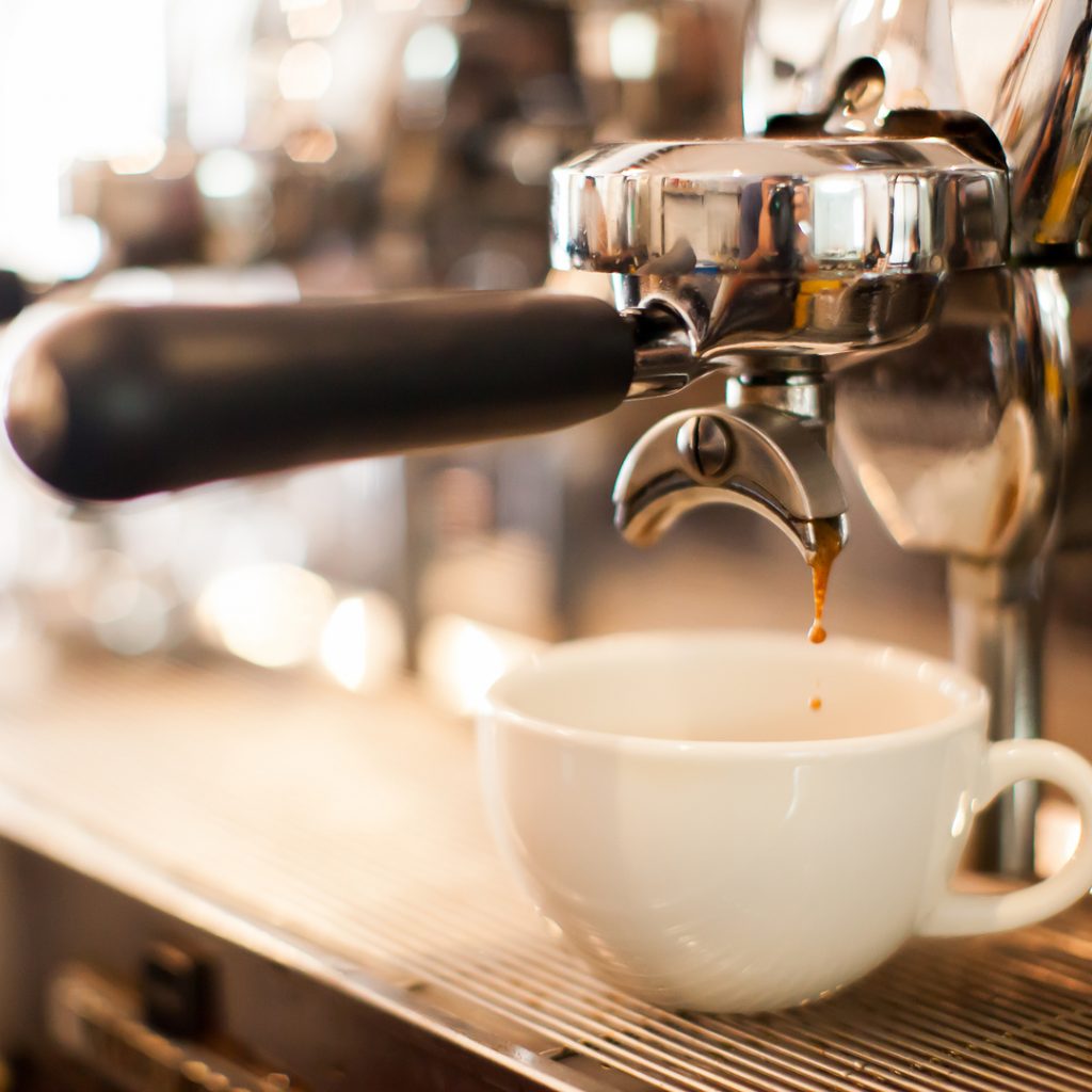 A cup of specialty coffee is being made on a deluxe coffee machine.