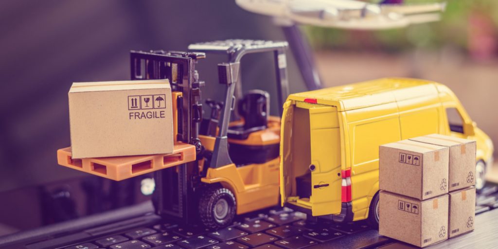 A toy forklift and boxes sit on a laptop keyboard to illustrate an effective ecommerce supply chain.