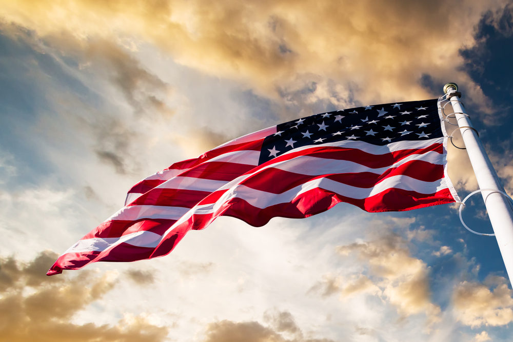An American flag waves beneath a beautiful evening sky.