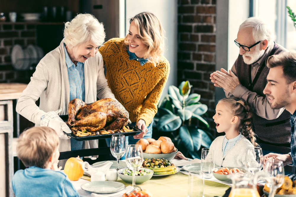 A grandmother serves up Thanksgiving turkey to her happy family.