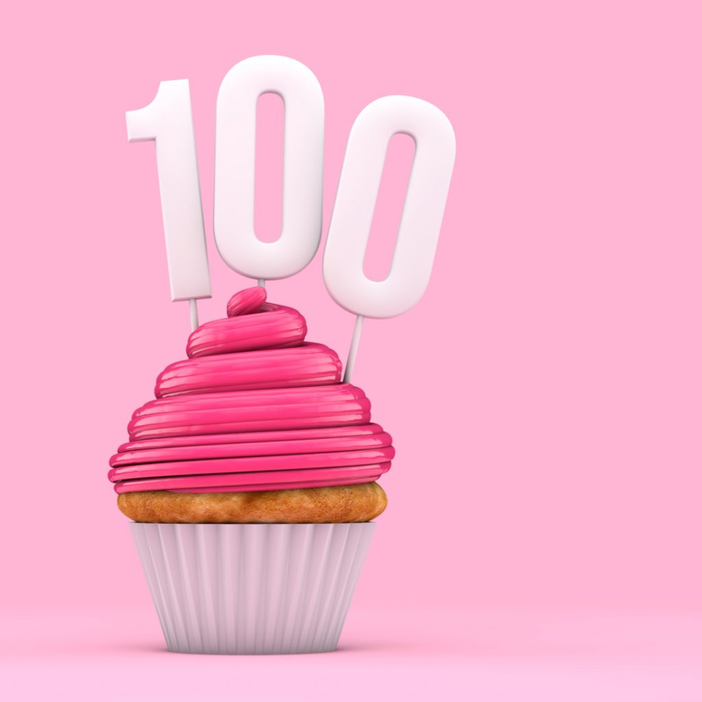 A pink cupcake sits with three candles that spell out, ''100'' - the number of auctions scheduled to start at the same time on DealDash on Cyber Monday!
