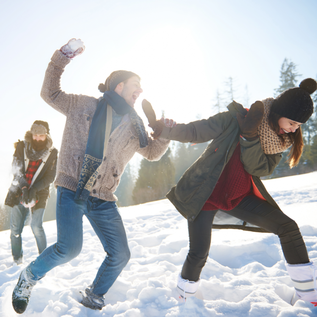 A group of friends enjoy a fun snowball fight together on a beautiful winter day.