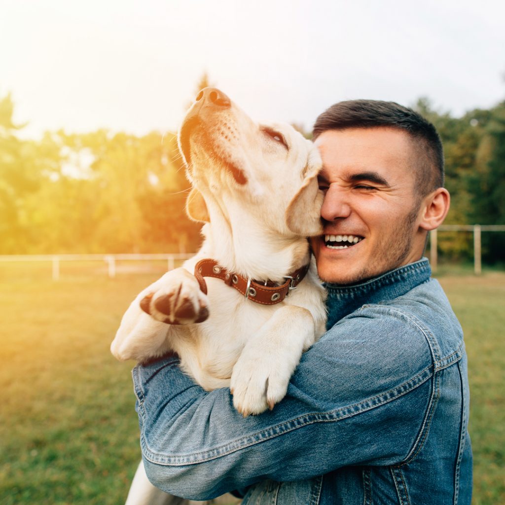 A man hugs his best friend, a Labrador retriever.