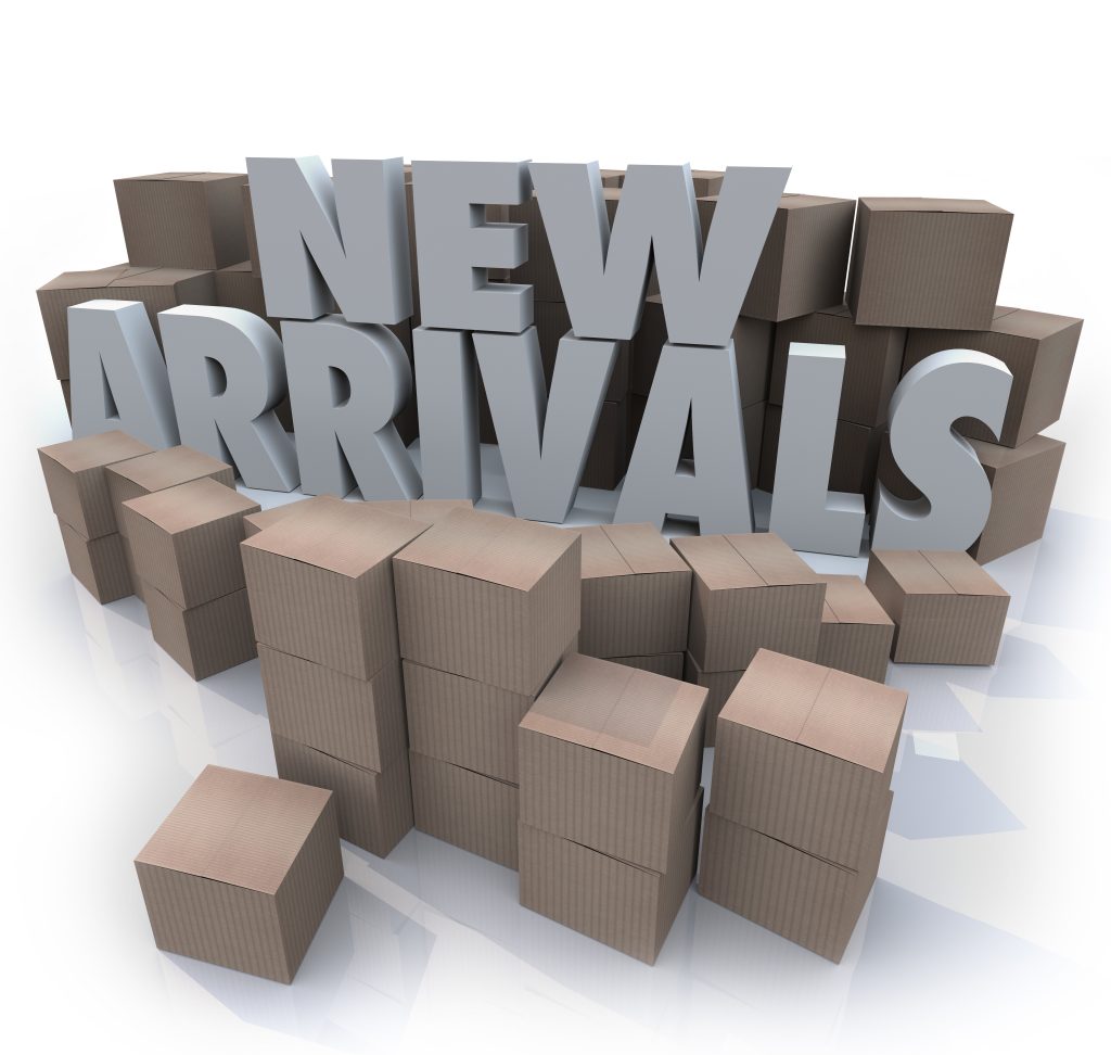 A stack of boxes stand behind large text that says, 'New Arrivals'.
